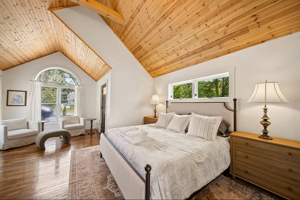 Restored hardwood floors and arched ceiling in this spacious primary bedroom