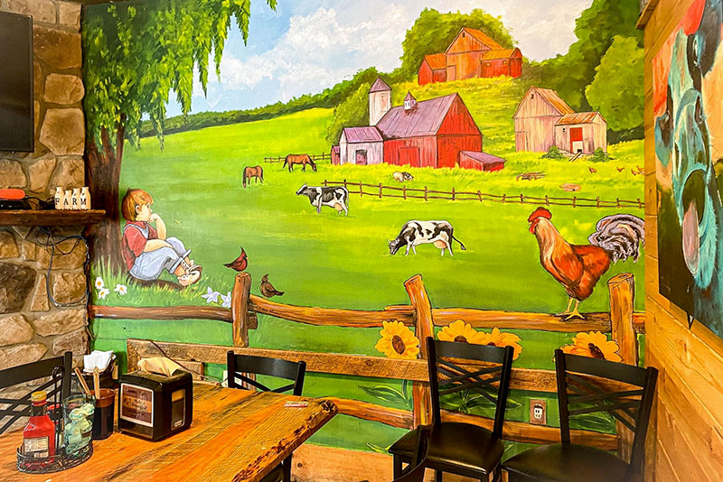 Cozy dining room with farm mural at Bella's Breakfast & Lunch
