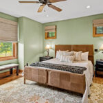 This master bedroom offers space and nice views of nature