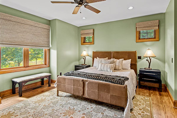 This master bedroom offers space and nice views of nature