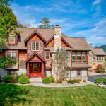 Aerial view of beautiful two-story vacation rental with mountain backdrop