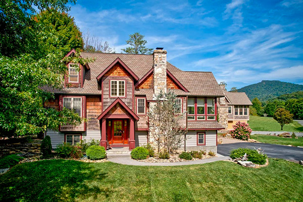 Aerial view of beautiful two-story vacation rental with mountain backdrop