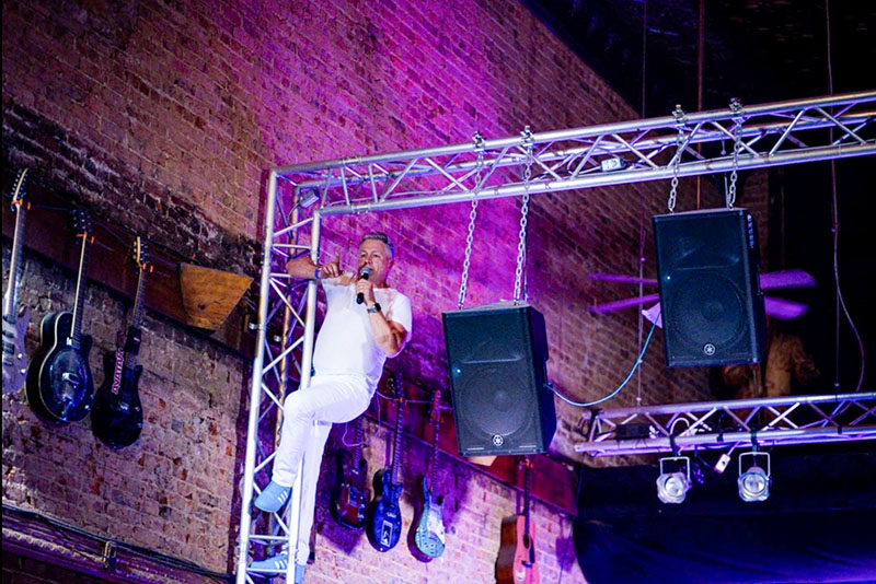 Jimmy Hinshaw of Saving Shirley sings from the scaffolding during a concert
