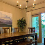 This vacation rental features a large dining room area with sliding door opening to private wooded balcony