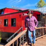 Acclaimed photographer Joseph Nitti stands in front of his red caboose gallery in Banner Elk NC