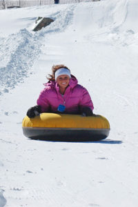 A tuber enjoys her day snowtubing in North Carolina at Sugar Mountain Resort near Banner Elk