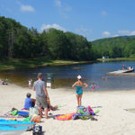 Families enjoy swimming and relaxing on the beach at Wildcat Lake in Banner Elk