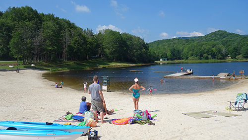 Families enjoy swimming and relaxing on the beach at Wildcat Lake in Banner Elk